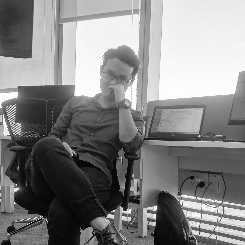 Black-and-white photo of Kenz Tran deep in thought at a laptop, illustrating the focused mindset behind MOCHIMIN’s development of AI automation tools like Lazy Prompter.